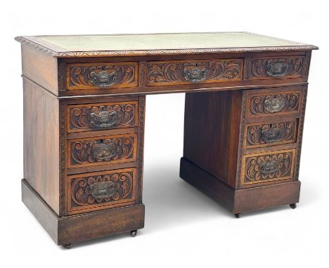 Late 19th century carved oak twin pedestal desk, rectangular top with inset leather writing surface, fitted with nine drawers