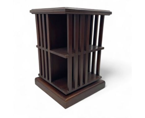 Early 20th century mahogany revolving bookcase, square form with moulded top, two tiers with vertical square slats, on plinth