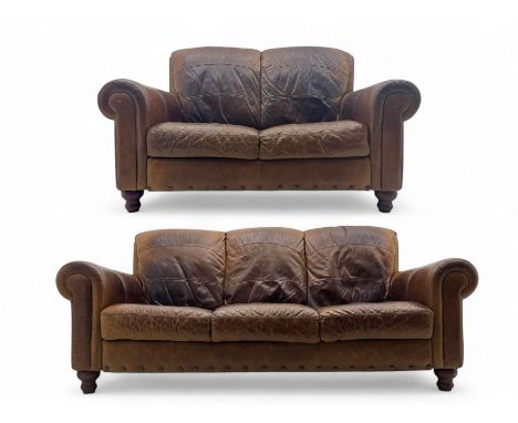 Contemporary three-seat sofa, in brown distressed leather with rolled arms and panelled backrest, raised on turned bun feet (