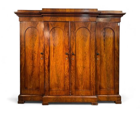 19th century mahogany break-fronted quadruple wardrobe, stepped and moulded projecting cornice over four arch panelled doors,