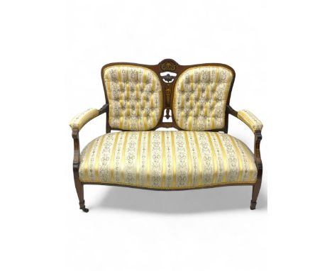 Edwardian rosewood two-seat settee, shaped back with inlaid decoration and carved crest, upholstered in striped fabric with c