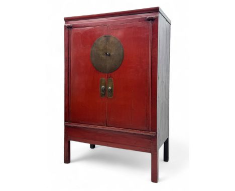 Chinese red lacquered storage cabinet, circular brass plate lock and matching drop handles, double doors opening to a shelved