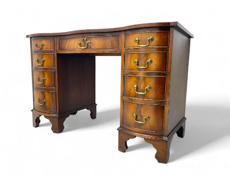 Early 20th century mahogany twin pedestal desk, serpentine top with gilt-tooled leather writing surface and central frieze dr