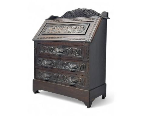 Late 19th century Jacobean design carved oak bureau, featuring a raised gallery with carved acanthus decoration above a slopi