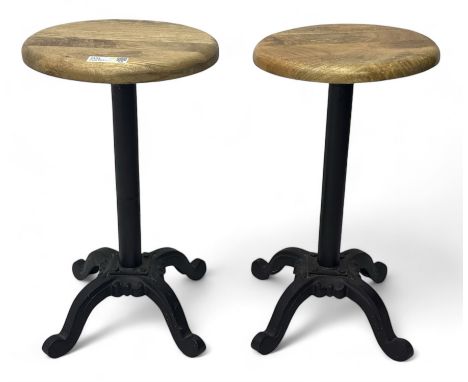 Pair of 20th century machinist stools, each with height-adjustable beechwood circular seats, supported by cast iron pedestal 