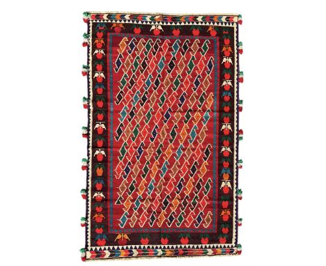 Southwest Persian Qashqai Kilim crimson ground rug, decorated with a repeating geometric pattern of interlocking diamond moti