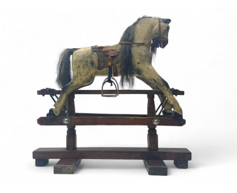 19th century rocking horse, carved wooden body with horsehair mane and tail, leather saddle, bridle and stirrups, raised on a