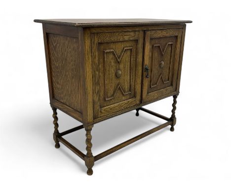 Early 20th century oak cabinet, rectangular top with rope-twist moulded edge, double doors with raised geometric panels, rais