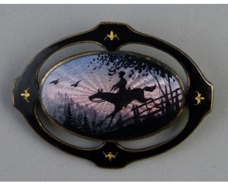A sterling silver and enamelled brooch, of pierced oval form with central oval panel depicting a figure on a horse jumping a 
