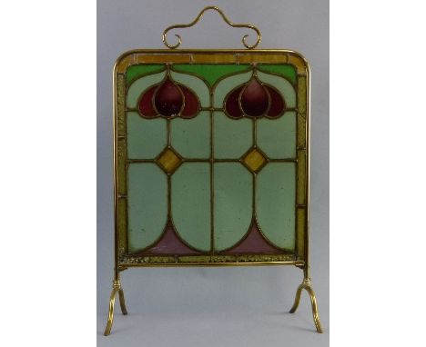 A tubular brass framed fire screen, with Art Nouveau style coloured leaded glass panel and scrolling handle, 77cm high, 51cm 