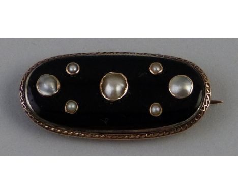A Victorian black enamel and pearl mourning brooch, the black enamelled curved oval panel collet set with seven pearls within