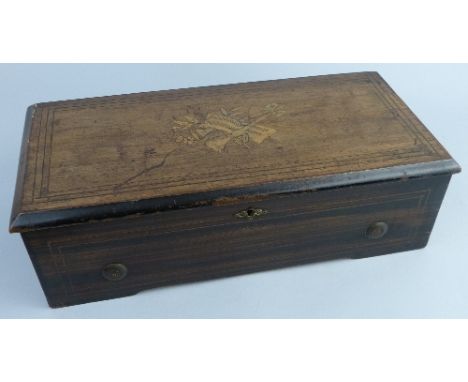A late 19th Century Swiss musical box, the simulated rosewood and ebonised case with marquetry musical trophies to the hinged