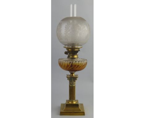 A table oil lamp, with brass stepped square base and Corinthian column stem supporting a wrythen fluted clear glass reservoir