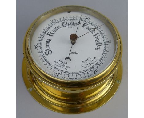 A ships style bulk head aneroid barometer, of typical circular form with brass case and enamelled dial inscribed "Sewill Live
