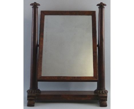 An early Victorian mahogany swing toilet mirror, the oblong mirror panel supported on two tapering circular columns with melo