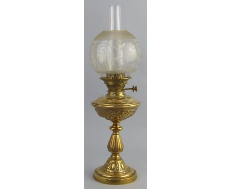 A table oil lamp, with brass stepped circular base, baluster stem and embossed reservoir with part frosted clear glass globul