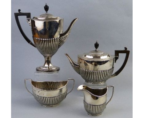 An Edwardian four piece tea set, the teapot of oval semi fluted form with ebonised urn finial on gadrooned hinged lid with si