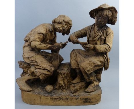 A Friedrich Goldscheider painted terracotta group, of two boys seated on a log playing cards, impressed signature mark, "Repr