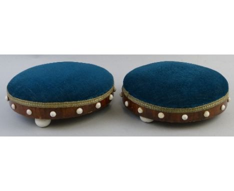 A pair of Victorian walnut foot stools, of circular form each with inset white ceramic cabouchons to the sides and three matc