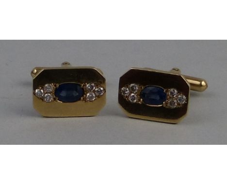 A pair of sapphire and diamond set cufflinks, each canted oblong 9ct gold panel centrally  set with a oval blue sapphire flan