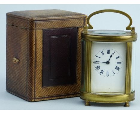 An early 20th Century French carriage clock, of oval form, the white enamelled dial with Roman numerals enclosing a brass eig