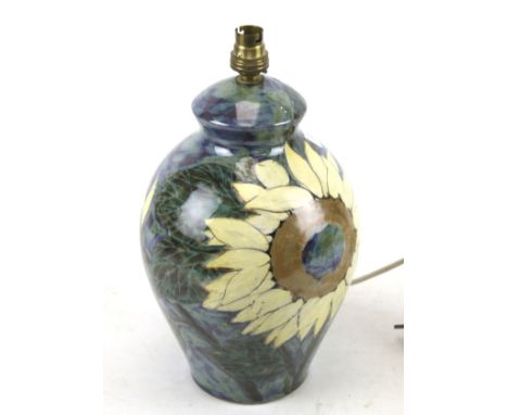 A Highlands stoneware hand painted lamp base. Decorated with sunflowers on a blue ground, signature to the base, H30cm (exclu