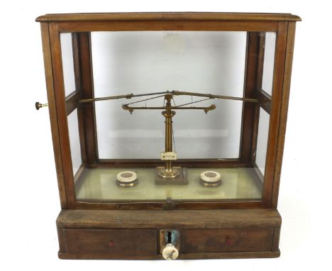 A cased set of apothecary scales by Dertling, London. Contained within a mahogany cabinet with two drawers, H49cm x W46cm x D