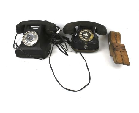 Two vintage telephones and a wooden jack. Both telephones black in colour