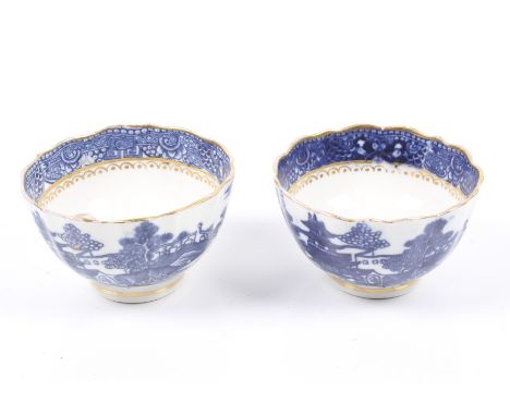 A pair of late 18th century caughley blue and white tea bowls. Decorated with pagoda patterns with gilt rims, Diameter 8cm