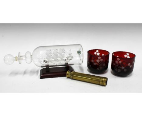 Glass ship in a bottle, two cranberry glass night light holders and a small brass telescope, 39cm extended (3) 