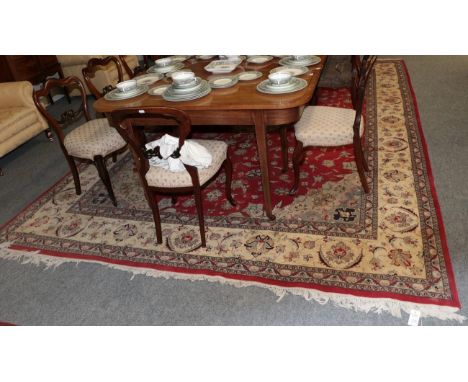 An Oriental carpet, Pakistan or India, the scarlet field of floral vines centred by a medallion, framed by spandrels and vine