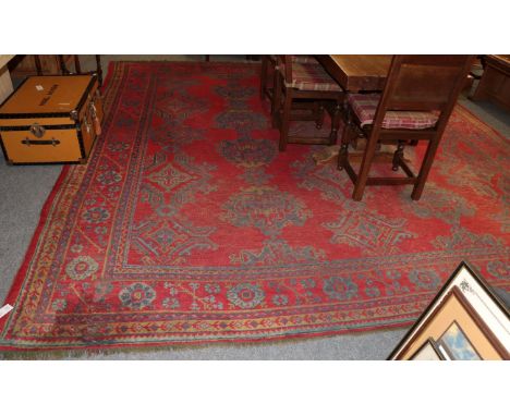 An Ushak carpet, the tomato red field of guls enclosed by plough head borders, 376cm by 364cm 