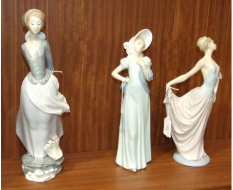 A Lladro figure of a young woman holding a book behind her back, 38cm high, another of a young woman dancer holding out her s