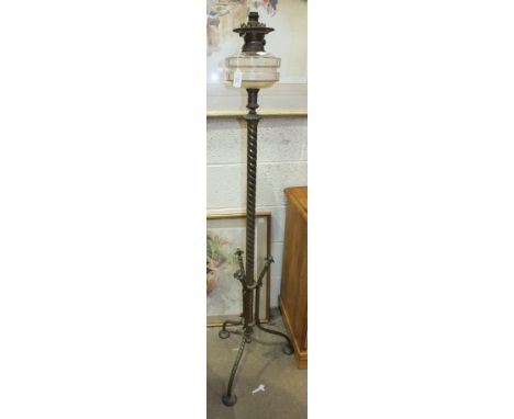 A late-19th/early-20th century oil lamp standard, the glass reservoir on twist brassed column and tripod support, (converted 