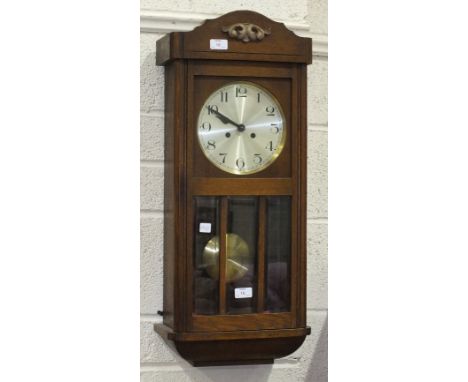 An oak case striking wall clock, 76cm high.