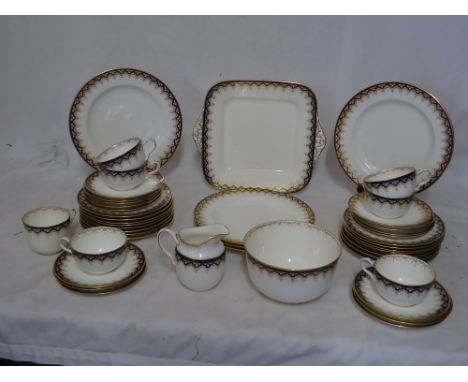 A Wedgwood Teaset decorated with a blue and gilt border pattern, comprising seven cups, sixteen saucers in two sizes, fifteen