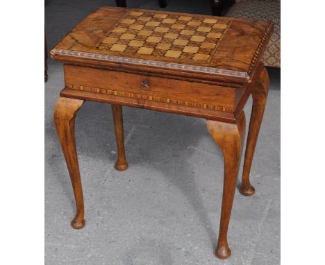 A late Victorian walnut Games Table, the oblong top inlaid for draughts and folding open for cribbage and cards, the interior