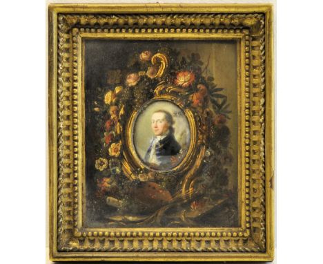 * An oval miniature head and shoulders Portrait of a Gentleman wearing a gold frogged blue coat, facing left, in a gilded fra