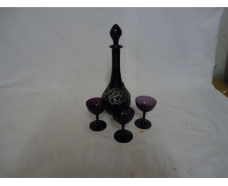 An amethyst glass Decanter with pewter overlaid decoration, three matching liqueur glasses and two decanters.