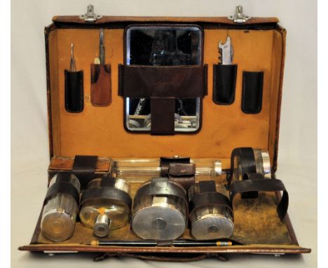 *  A gentleman's leather Travelling Dressing Case fitted with glass and silver mounted bottles etc. with engine turned covers