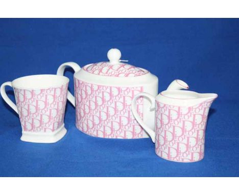 DIOR TEA SERVICE,
decorated in pink on white, including a teapot, sugar and cream, mugs, bowls and plates