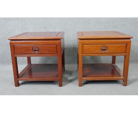 A pair of Chinese carved hardwood bedside or lamp tables, each fitted with frieze drawer on square tapering supports united b