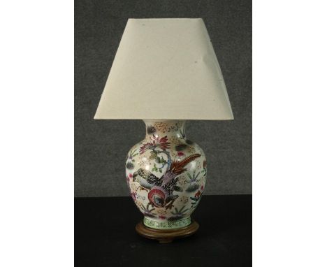 A 20th century Oriental vase converted to a table lamp mounted on a hardwood base. Decorated with a pheasant and floral desig