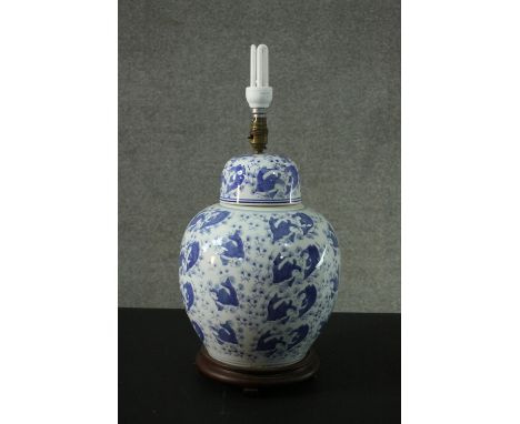 A 20th century Chinese blue and white ceramic lidded ginger jar table lamp. Decorated with goldfish and water weeds, mounted 