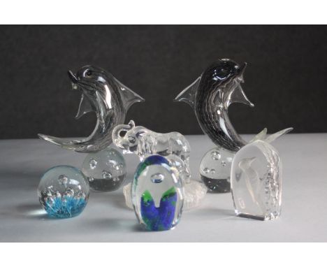 A collection of six art glass paper weights. A pair of dolphins balancing on balls, mum and baby elephant, a woodpecker and t