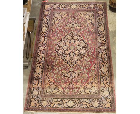 Eastern wool rug&nbsp;of Persian design, having black arabesque to the cherry red field with allover floral filled botehs, fl