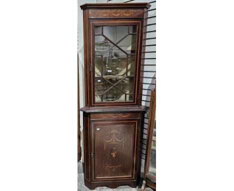 Early 20th century mahogany and satinwood corner cabinet inlaid with a basket and swags and bows, the upper section with an a