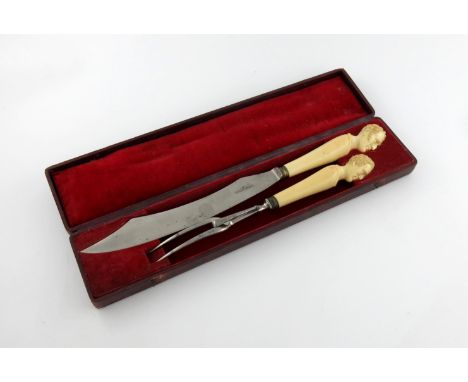 λ A Victorian carved ivory handled carving knife and fork, by J. Rodgers and Sons, Sheffield, the knife carved with the head 