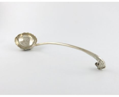 An 18th century silver soup ladle, unmarked, the outside of the fluted bowl with shell decoration, the handle with birds head