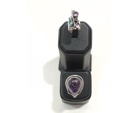 A white metal ring set with purple and blue stones (probably amethyst and peridot); together with an amethyst ring, the pear 